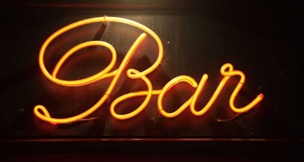 Yellow neon sign that says Bar