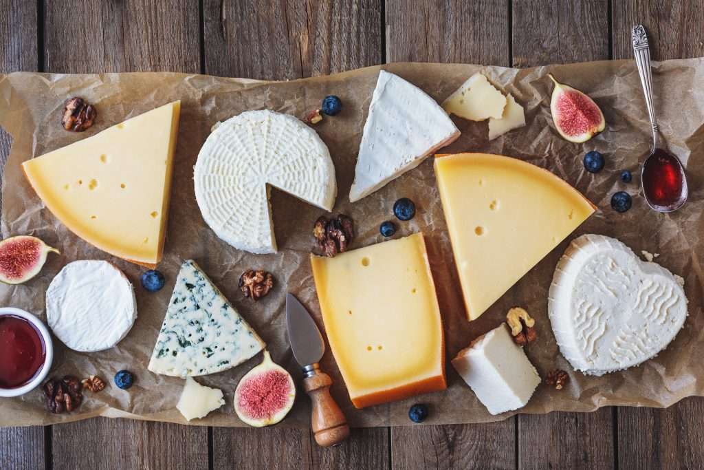 various types of cheese on rustic table top view