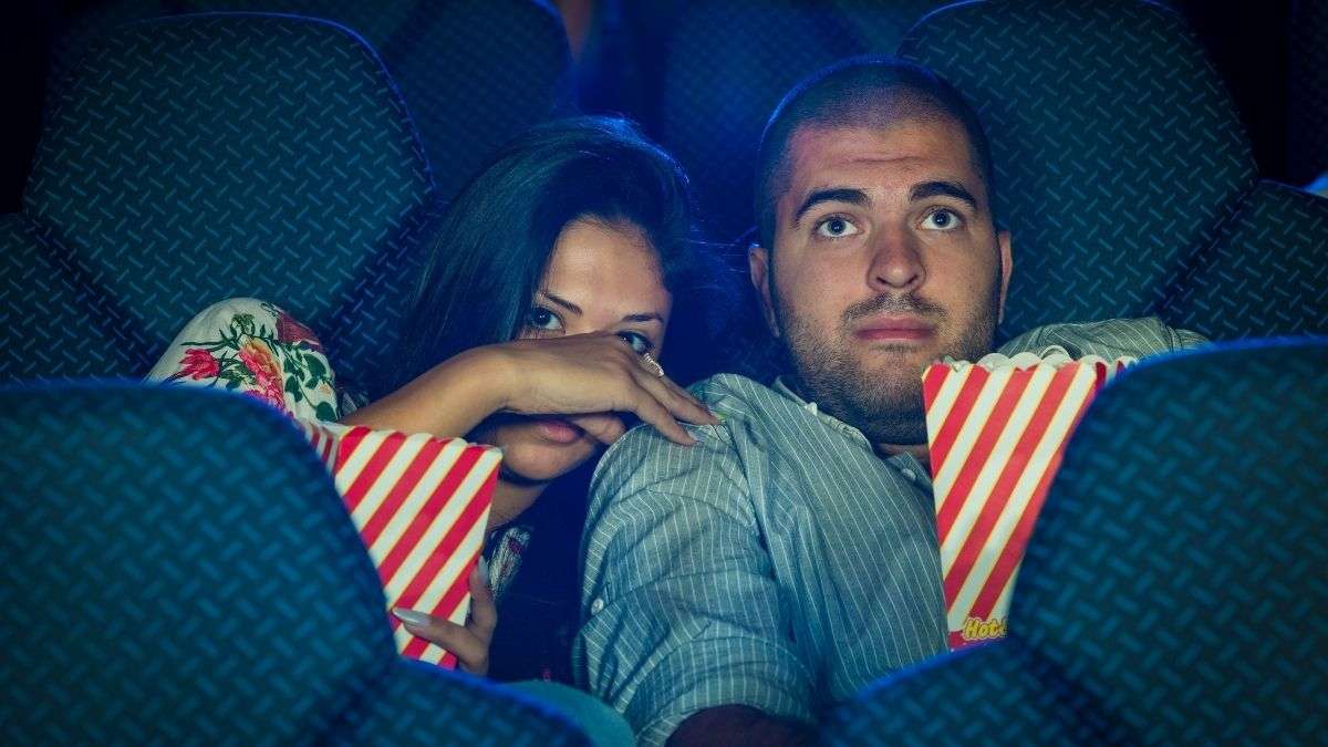 couple watching horror movie with popcorn
