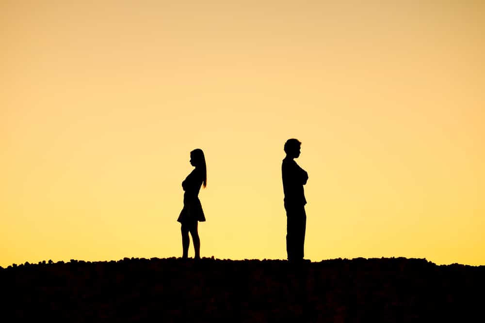 silhouette of woman and man standing apart and away from each other