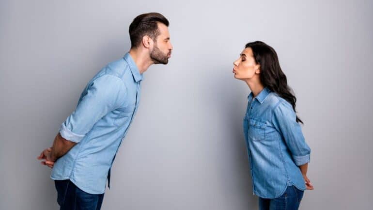 couple standing apart looking at each other kissing faces