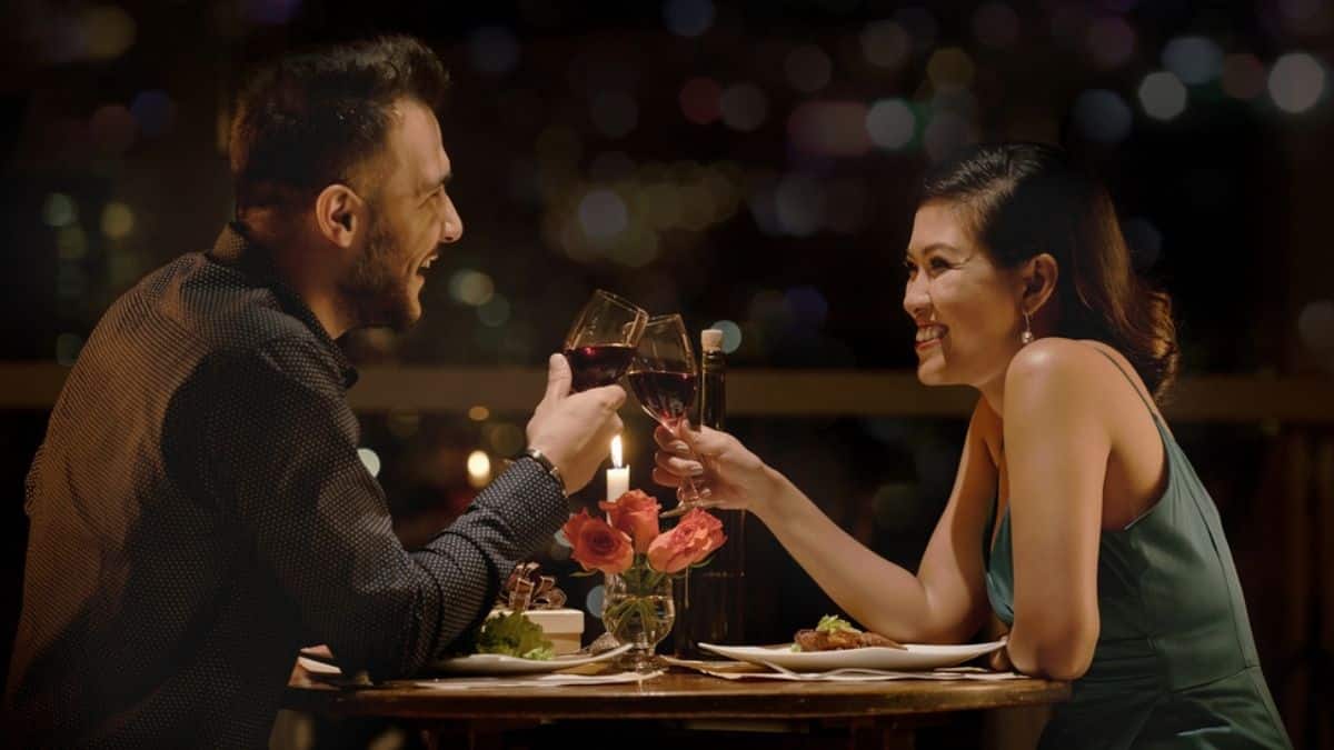 woman and man on date clinking wine glasses