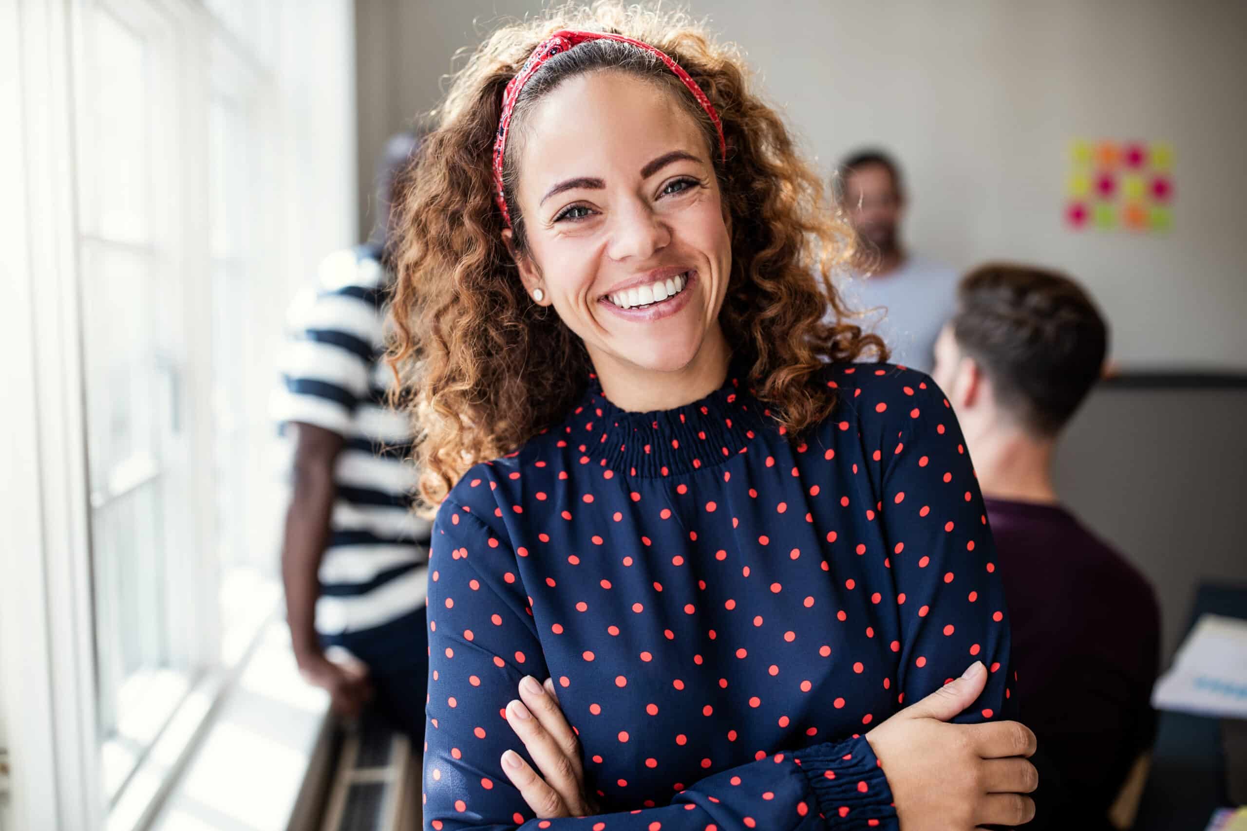 girl with polka dot shirt and curly hair smiling